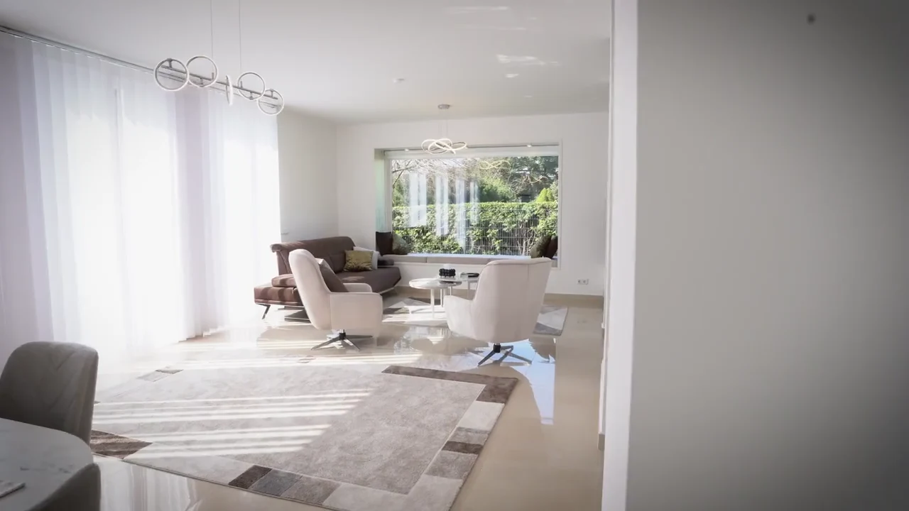Helles Wohnzimmer mit großen Fenstern, aufgenommen für einen Immobilienfilm